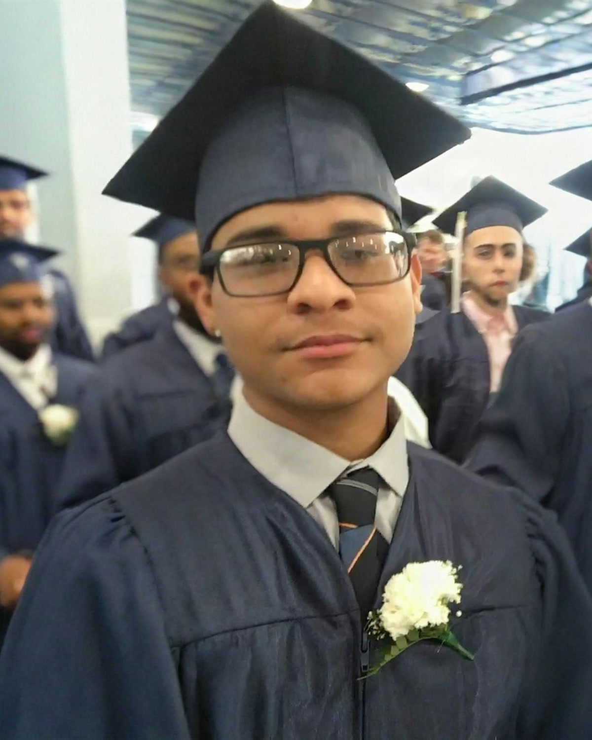 Amel Perez Cavallo in a cap and gown at his Lawrence High School graduation